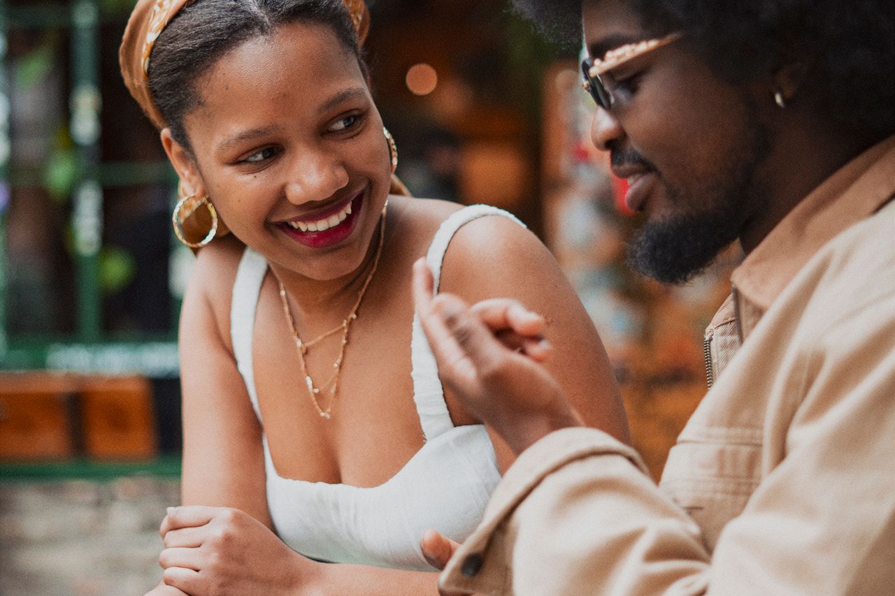 Man and woman laughing during a conversation outdoors